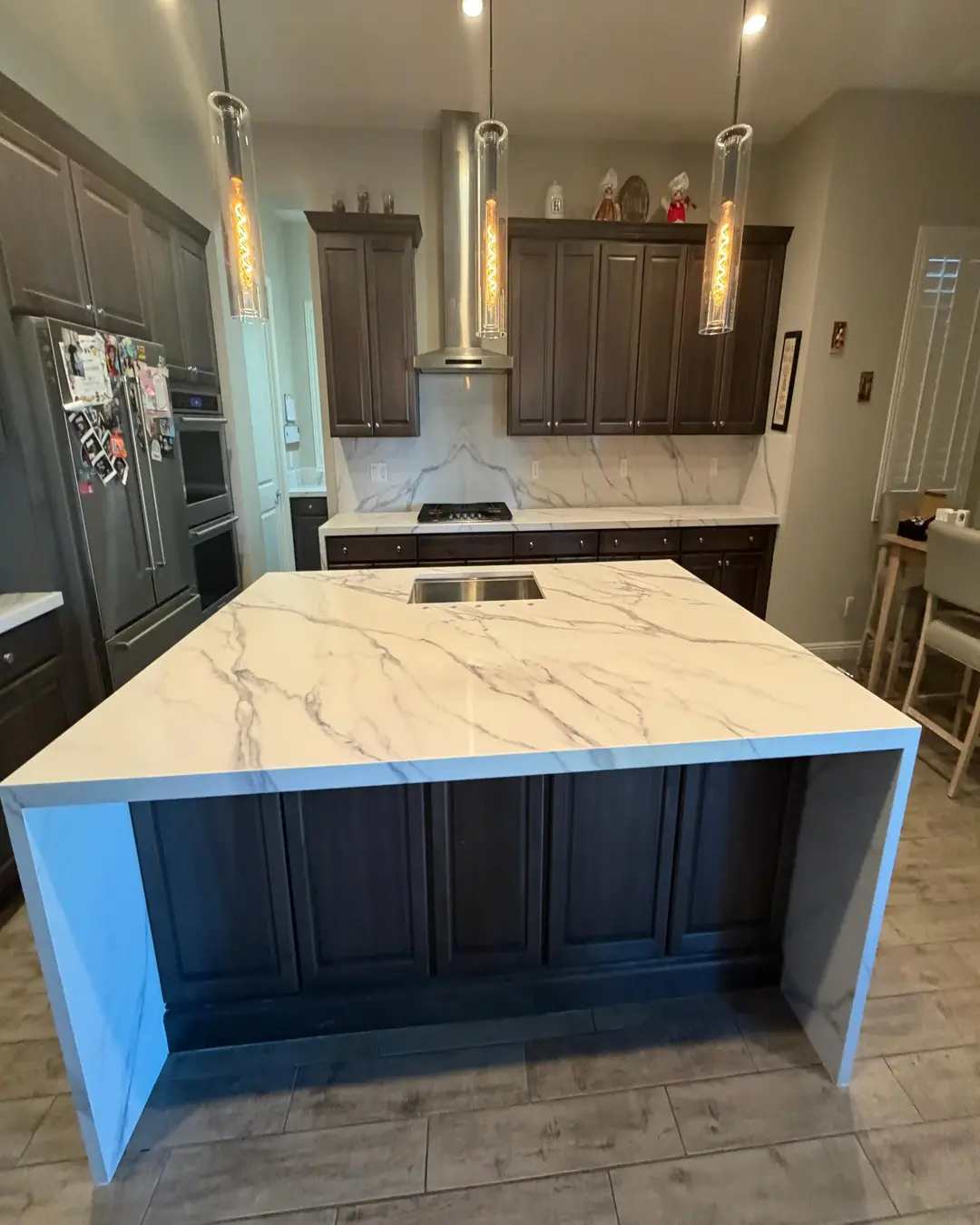 Finished kitchen island with stone surface and modern lighting by Pro Vegas Home Remodel