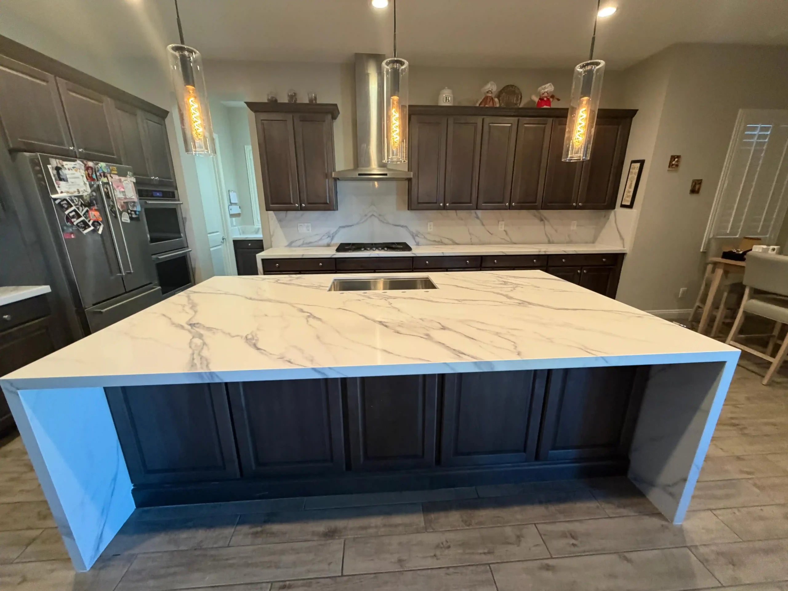 Finished kitchen island with stone surface and modern lighting by Pro Vegas Home Remodel