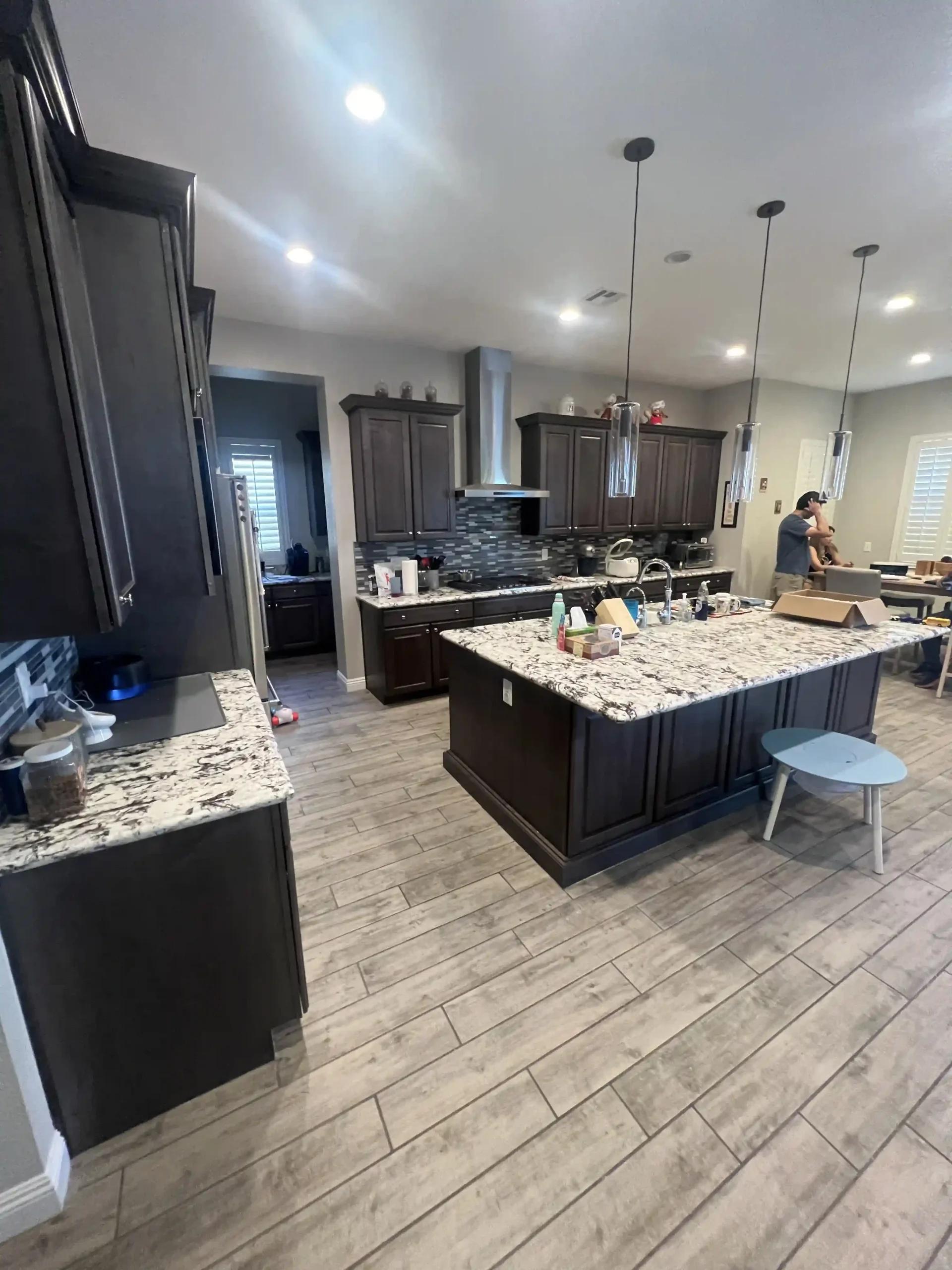 Open concept kitchen featuring a central island and stone countertops completed by Pro Vegas Home Remodel
