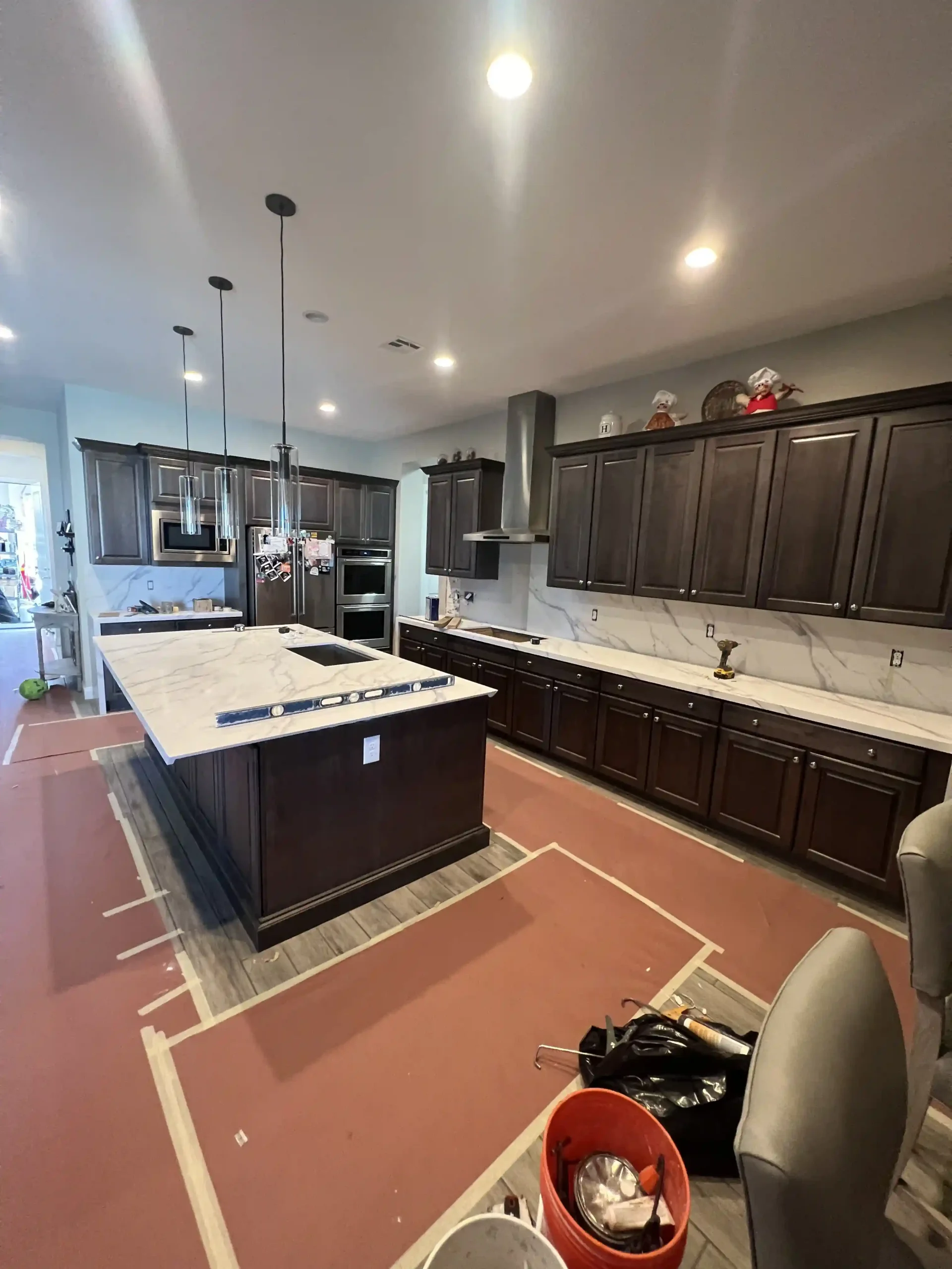 Modern kitchen remodel with dark wood cabinets, large island, and pendant lighting by Pro Vegas Home Remodel