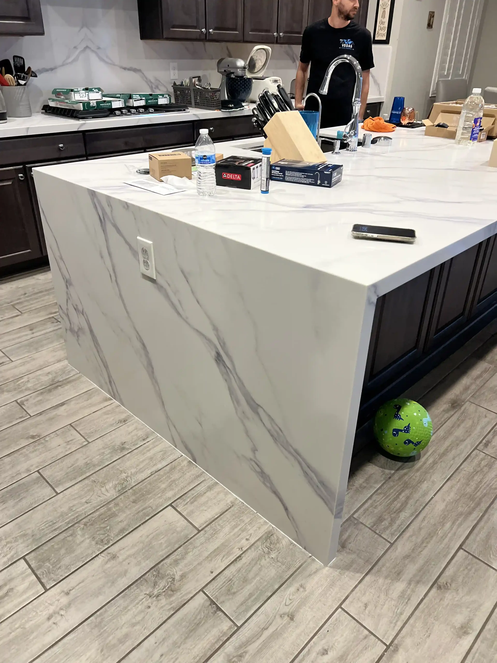 Waterfall edge kitchen island with marble-style slab crafted by Pro Vegas Home Remodel