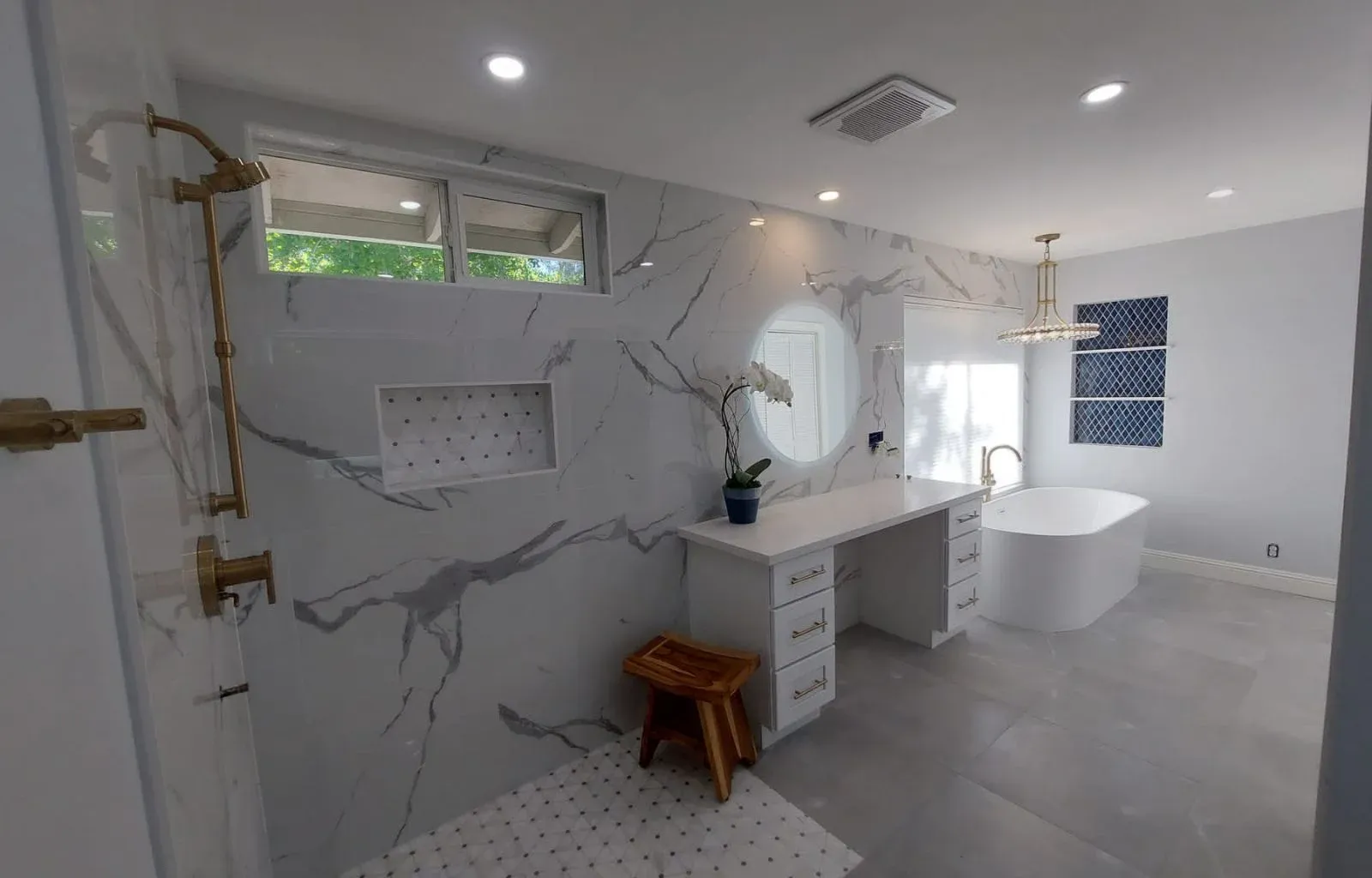 Bathroom renovation showcasing timeless marble finishes and gold fixtures